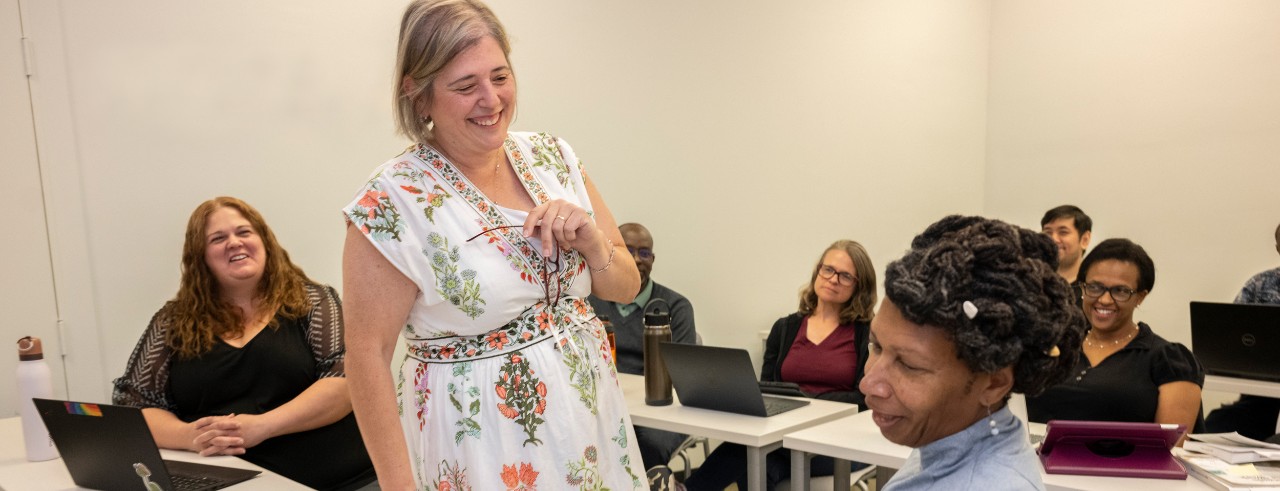 Dr. Kim Johnson talking with PhD students in classroom